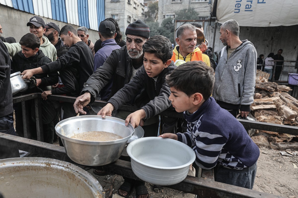تلقى فلسطينيون، بينهم أطفال، وجبات ساخنة وزعتها إحدى الجمعيات الخيرية في مخيم النصيرات للاجئين، وسط نقص حاد في الغذاء ناجم عن الهجمات الإسرائيلية المستمرة وتدهور الأوضاع الإنسانية. النصيرات، وسط قطاع غزة. 26 يناير/كانون الثاني 2026. تصوير: معز صالحي