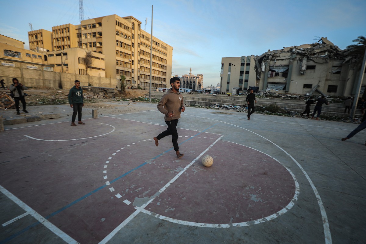   شبان فلسطينيون نازحون يلعبون كرة القدم في ملعب مدمر بمدينة غزة، في 10 يناير/كانون الثاني 2026. صورة: عمر أشتوي