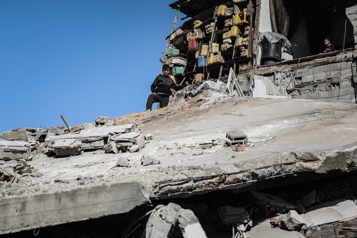 فلسطينيون يتفقدون منزلاً (تضرر سابقاً جراء غارة جوية إسرائيلية) انهار على سكانه، ما أسفر عن وفاة رجل ونجله الصغير في مخيم المغازي للاجئين وسط قطاع غزة، 5 يناير/كانون الثاني 2026. صورة: رمزي أبو عامر