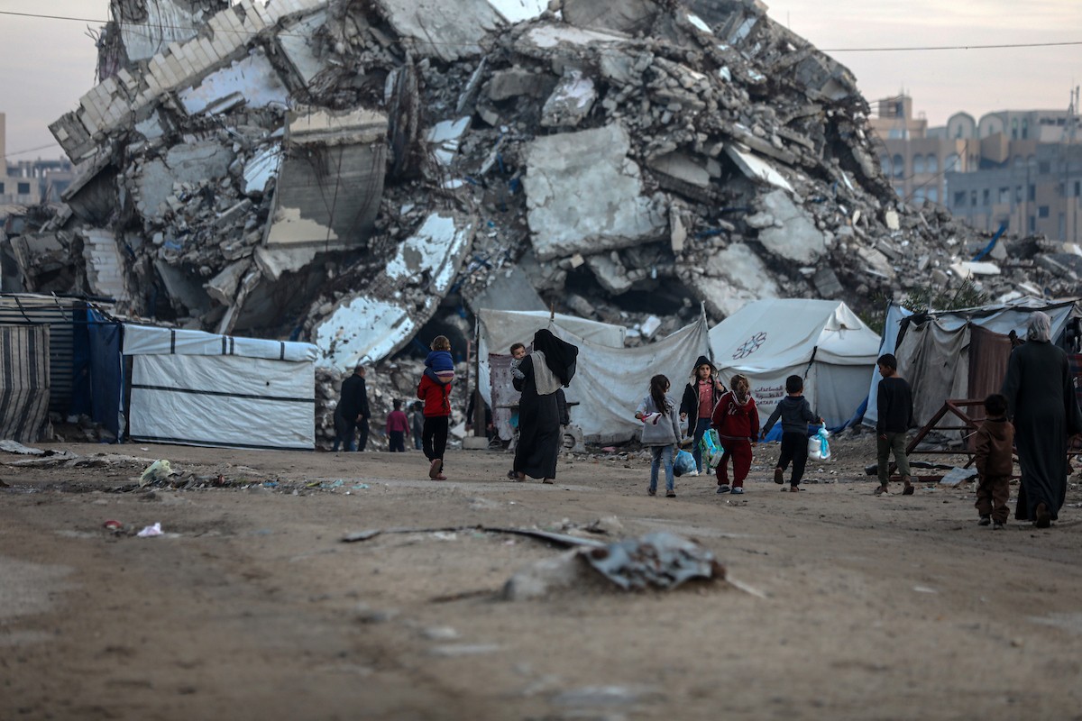 يسير فلسطينيون في شوارع مدينة غزة، وسط الأنقاض والدمار الذي خلفه الصراع الدائر، في 10 يناير/كانون الثاني 2026، بينما تستمر الحياة اليومية في ظل ظروف صعبة. صورة: عمر أشتوي
