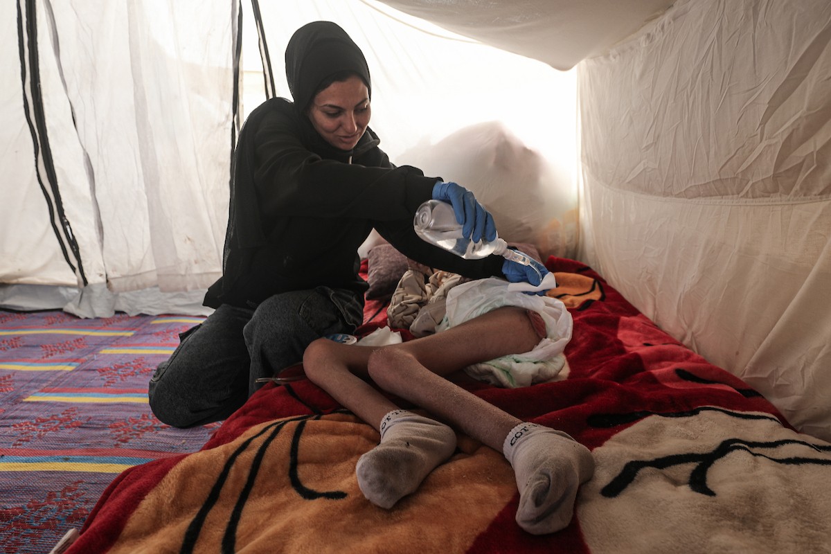 الطفل سيف رامي حجازي (13 عاما) أُصيب بشلل كامل وفشل كلوي إثر قصف إسرائيلي لخيمة عائلته، وتتولى والدته رعايته في ظروف إنسانية بالغة الصعوبة بمخيم المغازي، وسط قطاع غزة، 30 يناير/كانون الثاني 2026. صورة: معز صالحي