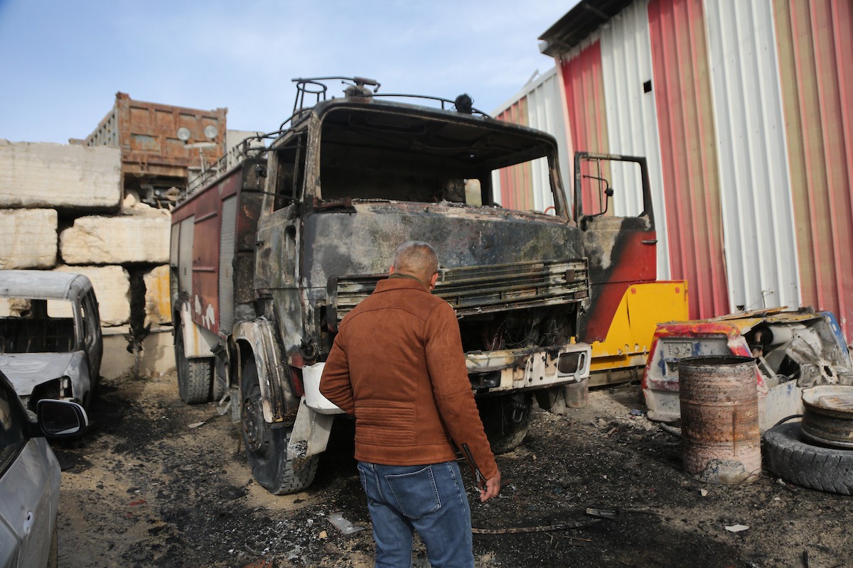 يتفقد الفلسطينيون الأضرار التي لحقت بمركباتهم وشاحناتهم وجرافاتهم بعد أن أضرم مستوطنون إسرائيليون النار فيها خلال هجوم شنوه على قرية عوريف، جنوب نابلس، في الضفة الغربية في 21 يناير/كانون الثاني 2026. صورة: محمد ناصر