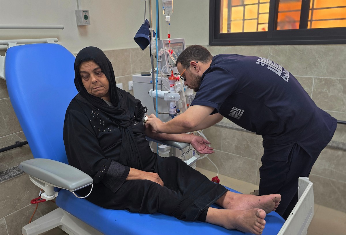 المسنّة عطاف جندية، تتلقى العلاج في مستشفى ناصر بمدينة خان يونس، بعد إصابتها بفشل كلوي ،في ظل النقص الحاد في الأدوية والمستلزمات الطبية والحالة الحرجة التي تعاني منها مستشفيات قطاع غزة،1 يناير/كانون الثاني 2026. تصوير: طارق محمد