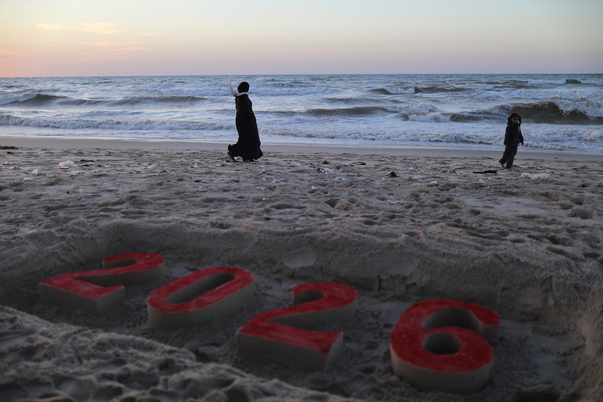 فلسطينيون يودعون عام 2025 بكتابة 2026 على رمال شاطئ غزة، 31 ديسمبركانون الأول 2025. صورة عمر أشتوي