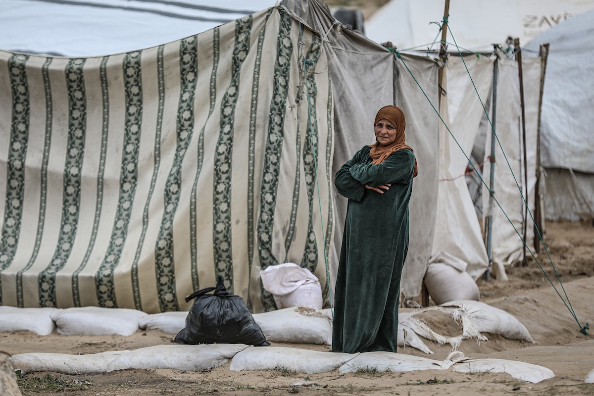 يتفقد فلسطينيون نازحون خيامهم بعد أن تضررت بشدة جراء عاصفة هوائية قوية ضربت مخيمًا للنازحين وسط قطاع غزة. 22 يناير/كانون الثاني 2026. تصوير: رمزي أبو عامر