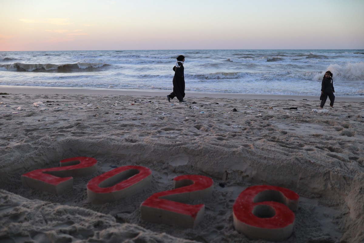 فلسطينيون يودعون عام 2025 بكتابة 2026 على رمال شاطئ غزة، 31 ديسمبركانون الأول 2025. صورة عمر أشتوي