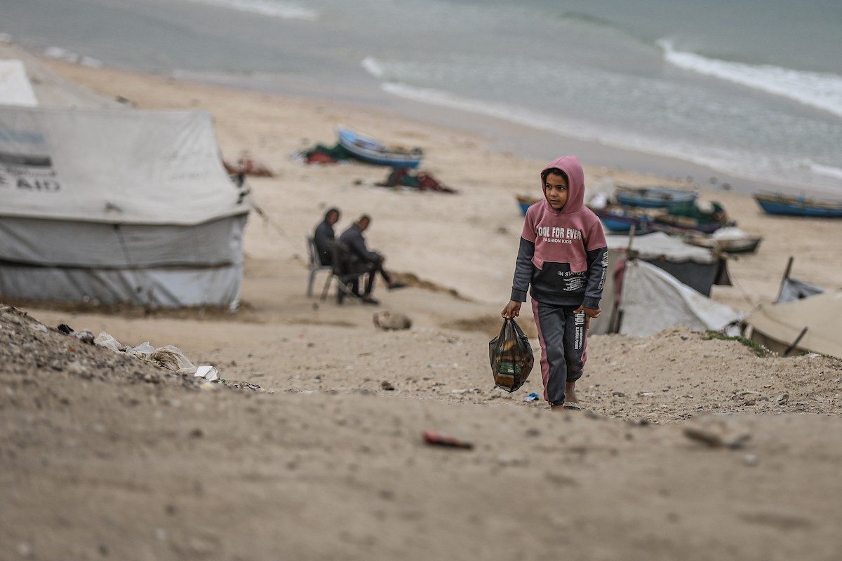 يتفقد فلسطينيون نازحون خيامهم بعد أن تضررت بشدة جراء عاصفة هوائية قوية ضربت مخيمًا للنازحين وسط قطاع غزة. 22 يناير/كانون الثاني 2026. تصوير: رمزي أبو عامر