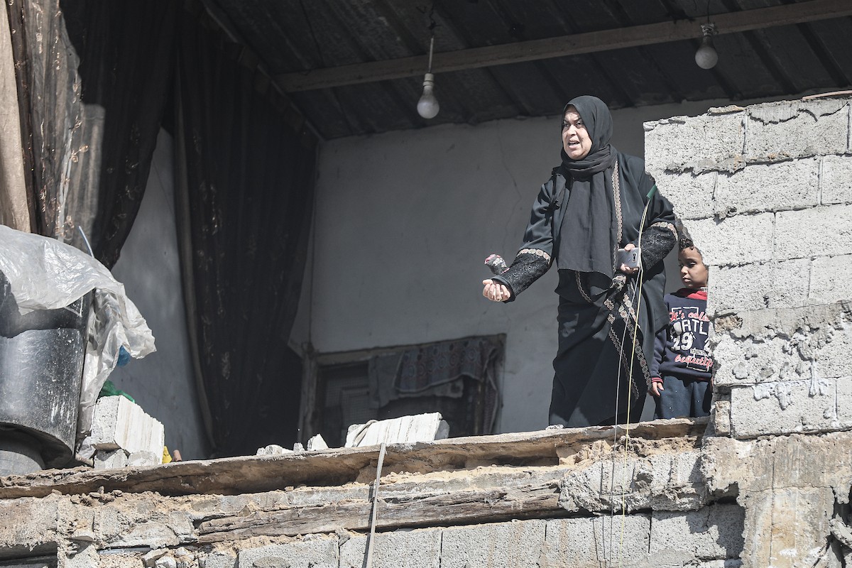 فلسطينيون يتفقدون منزلاً (تضرر سابقاً جراء غارة جوية إسرائيلية) انهار على سكانه، ما أسفر عن وفاة رجل ونجله الصغير في مخيم المغازي للاجئين وسط قطاع غزة، 5 يناير/كانون الثاني 2026. صورة: رمزي أبو عامر