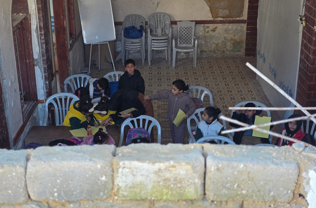 يتلقى الأطفال تعليمهم في أحد المراكز التعليمية بمدينة خان يونس جنوب قطاع غزة وسط مخاوف مستمرة من الغارات الإسرائيلية، نظرًا لموقعها القريب من 