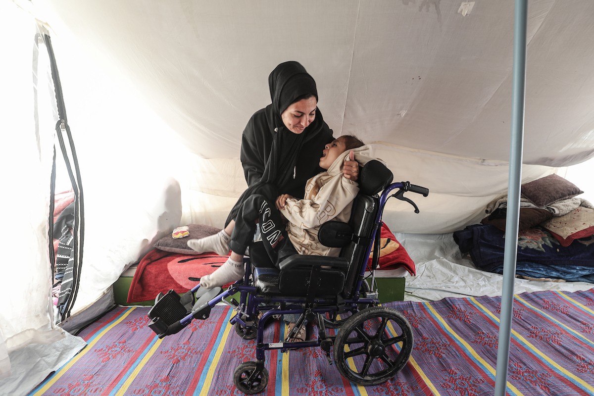 الطفل سيف رامي حجازي (13 عاما) أُصيب بشلل كامل وفشل كلوي إثر قصف إسرائيلي لخيمة عائلته، وتتولى والدته رعايته في ظروف إنسانية بالغة الصعوبة بمخيم المغازي، وسط قطاع غزة، 30 يناير/كانون الثاني 2026. صورة: معز صالحي