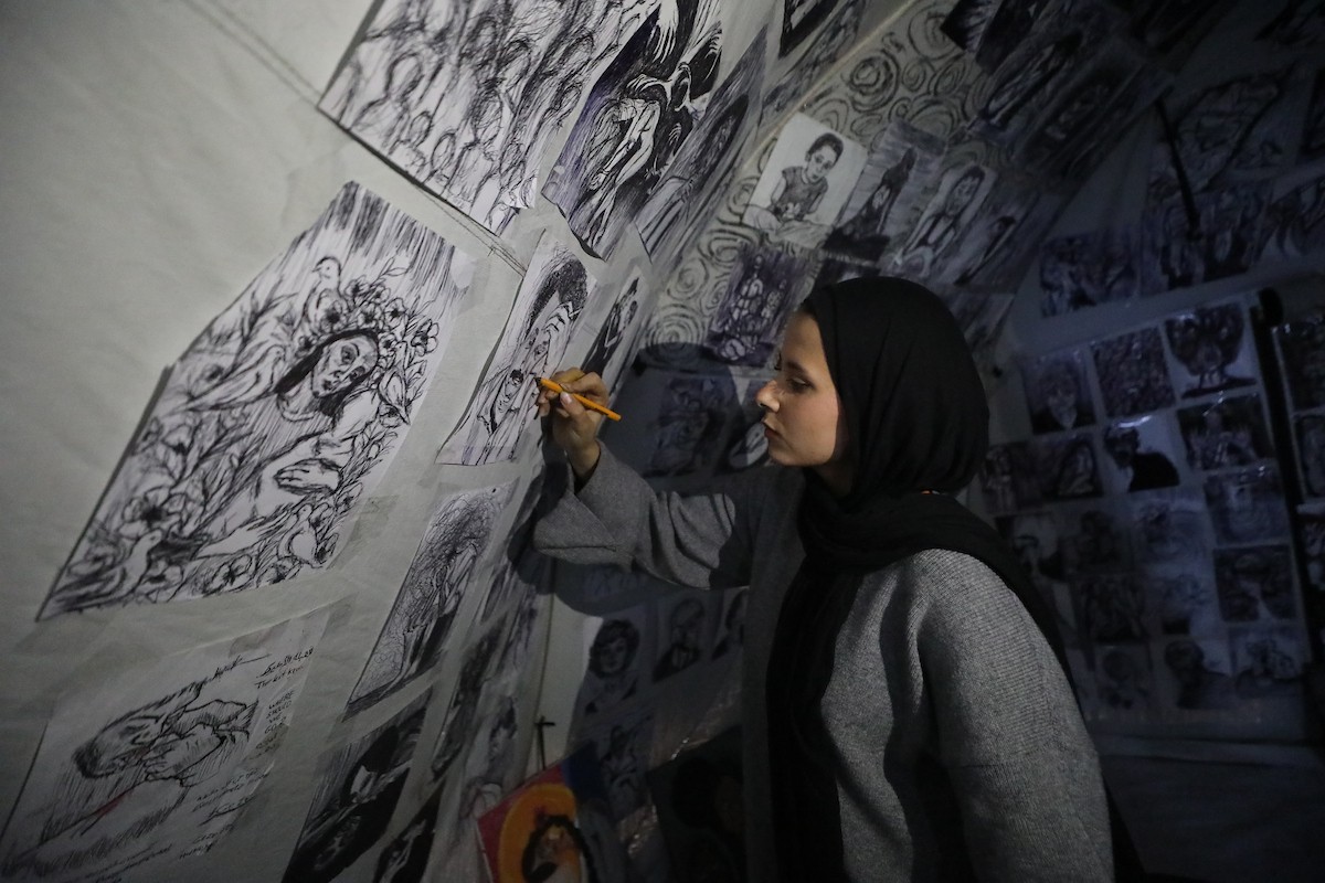 الفلسطينية مرَح خالد الزعانين (18 عاما) تحول خيمة نزوحها في مدينة غزة إلى معرض فني، 28 يناير/كانون الثاني 2026. تصوير: عمر أشتوي