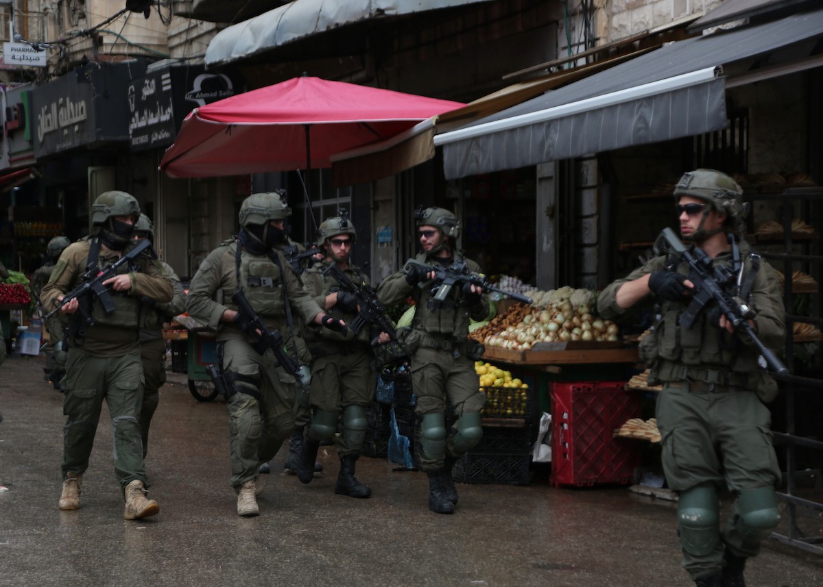 القوات الإسرائيلية تداهم عدد من المحال التجارية في السوق المركزي وتطلق النار تجاه بناية سكنية، وتوقف عدد من المواطنين في البلدة القديمة بمدينة نابلس، 1 يناير/كانون الثاني ٢٠٢٦. صورة: محمد ناصر