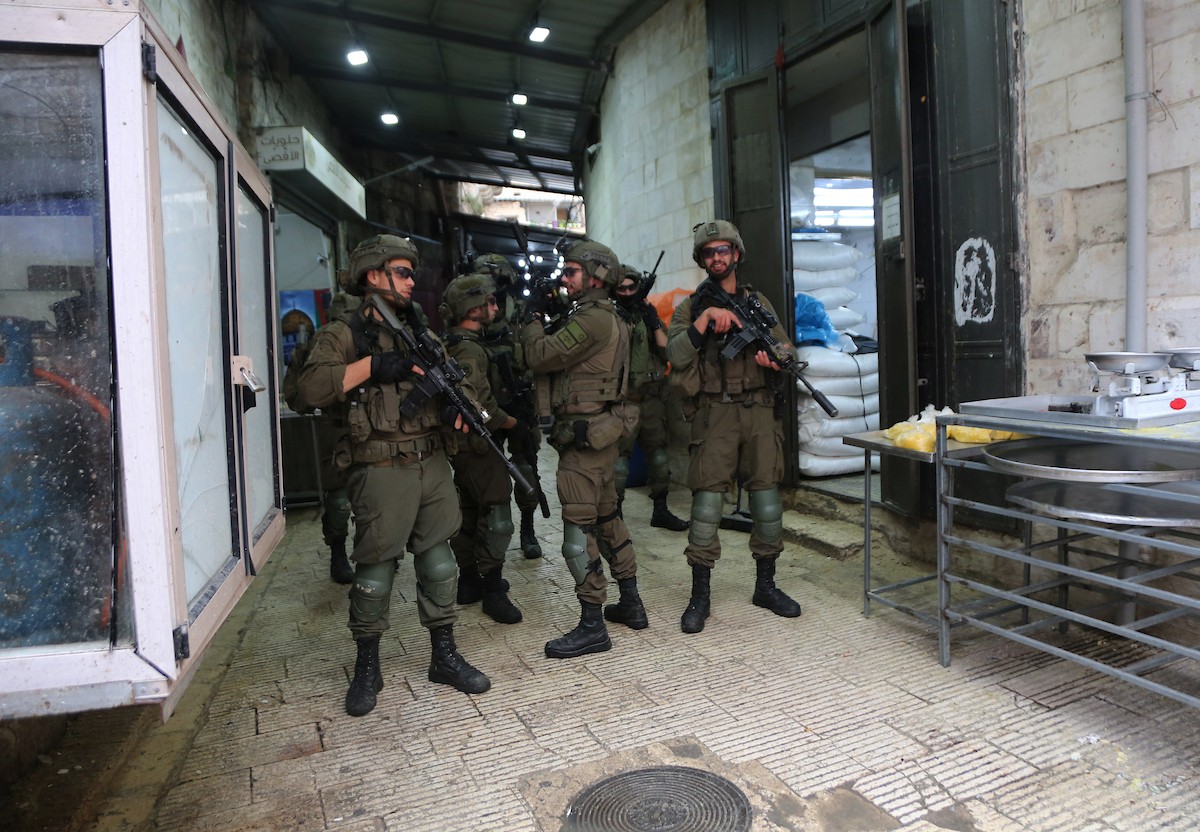 القوات الإسرائيلية تداهم عدد من المحال التجارية في السوق المركزي وتطلق النار تجاه بناية سكنية، وتوقف عدد من المواطنين في البلدة القديمة بمدينة نابلس، 1 يناير/كانون الثاني ٢٠٢٦. صورة: محمد ناصر