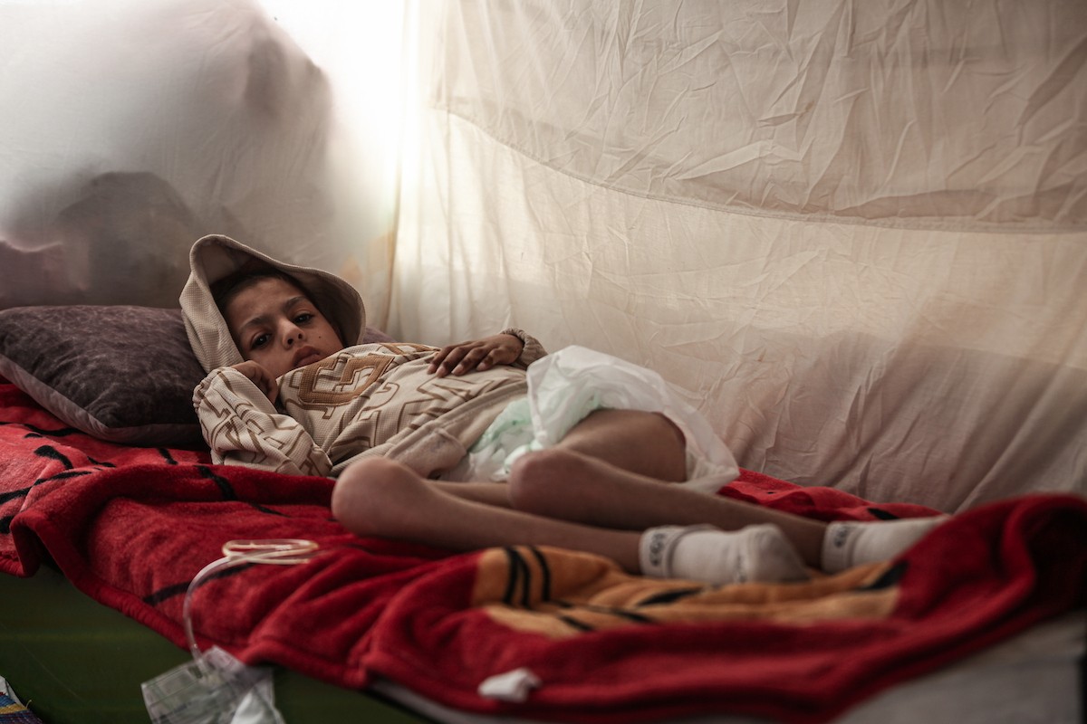 الطفل سيف رامي حجازي (13 عاما) أُصيب بشلل كامل وفشل كلوي إثر قصف إسرائيلي لخيمة عائلته، وتتولى والدته رعايته في ظروف إنسانية بالغة الصعوبة بمخيم المغازي، وسط قطاع غزة، 30 يناير/كانون الثاني 2026. صورة: معز صالحي