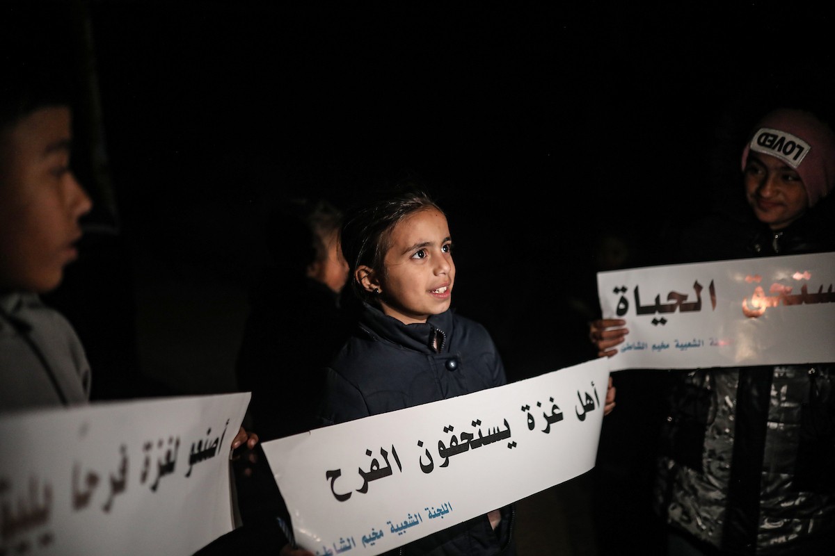 أطفال في وقفة احتجاجية في مخيم الشاطئ غرب مدينة غزة ليلة رأس السنة الميلادية 2026، 1 يناير/كانون الثاني 2026. تصوير: عمر أشتوي
