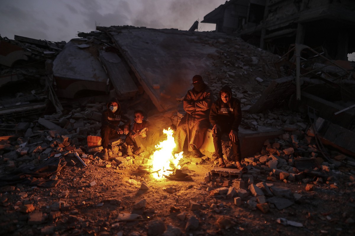 عائلات تعيش في خيام مؤقتة وسط الأنقاض تشعل نيرانًا للتدفئة في جباليا، شمال قطاع غزة، في 12 يناير/كانون الثاني 2026. ويكافح الفلسطينيون الذين دُمرت منازلهم في هجمات إسرائيلية من أجل البقاء في ظل ظروف شتوية قاسية وبرد قارس. صورة: عمر أشتوي