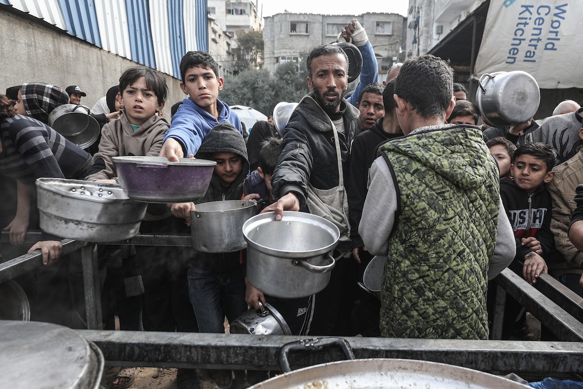 تلقى فلسطينيون، بينهم أطفال، وجبات ساخنة وزعتها إحدى الجمعيات الخيرية في مخيم النصيرات للاجئين، وسط نقص حاد في الغذاء ناجم عن الهجمات الإسرائيلية المستمرة وتدهور الأوضاع الإنسانية. النصيرات، وسط قطاع غزة. 26 يناير/كانون الثاني 2026. تصوير: معز صالحي