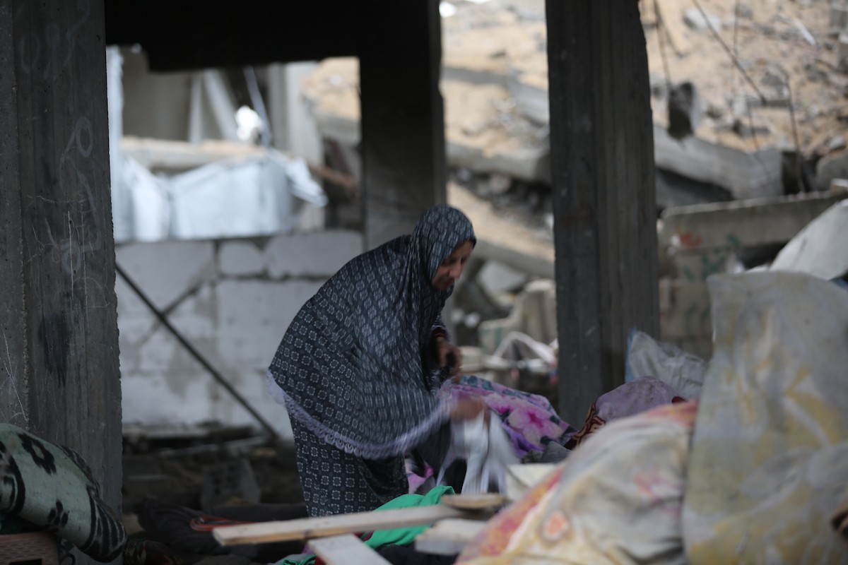 يبحث فلسطينيون عن ممتلكاتهم بين الأنقاض بعد أن دمرت غارات جوية إسرائيلية مبنى في مخيم البريج للاجئين وسط قطاع غزة. دمر الهجوم المبنى بالكامل وألحق أضرارًا بالمنشآت المحيطة به، 9 يناير/كانون الثاني 2026. صورة: معز صالحي