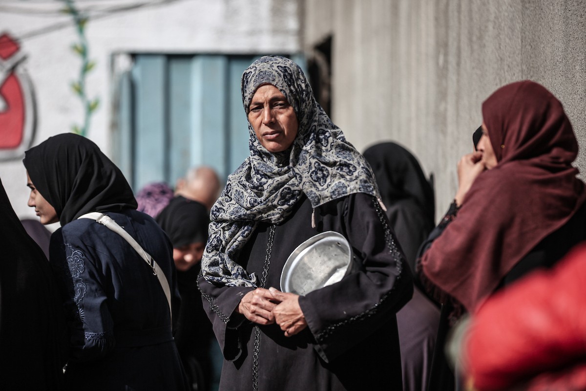 أطفال فلسطينيون ينتظرون وجبة ساخنة، توزعها إحدى المنظمات الخيرية، في ظل استمرار أزمة الغذاء بسبب محدودية المساعدات الإنسانية في مخيم النصيرات للاجئين وسط قطاع غزة، في 10 يناير/كانون الثاني 2026. صورة: معز صالحي