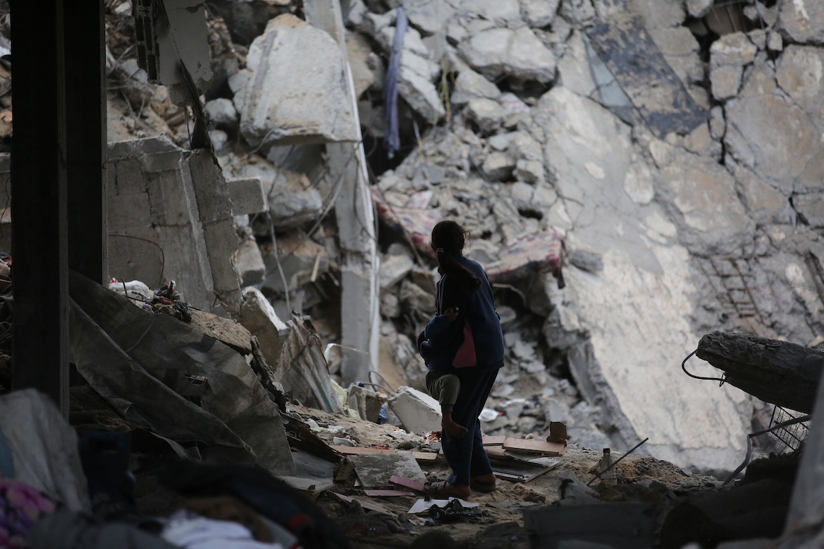 يبحث فلسطينيون عن ممتلكاتهم بين الأنقاض بعد أن دمرت غارات جوية إسرائيلية مبنى في مخيم البريج للاجئين وسط قطاع غزة. دمر الهجوم المبنى بالكامل وألحق أضرارًا بالمنشآت المحيطة به، 9 يناير/كانون الثاني 2026. صورة: معز صالحي