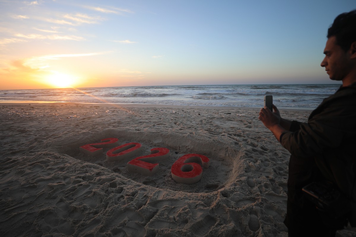 فلسطينيون يودعون عام 2025 بكتابة 2026 على رمال شاطئ غزة، 31 ديسمبركانون الأول 2025. صورة عمر أشتوي