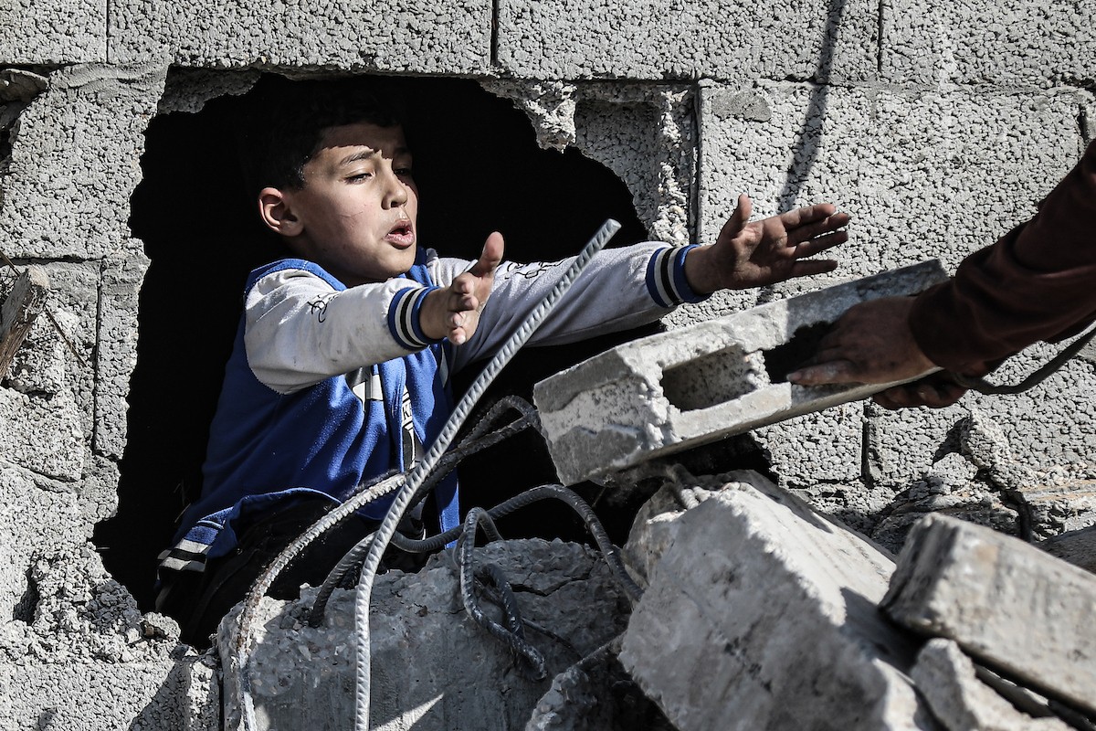 فلسطينيون يتفقدون منزلاً (تضرر سابقاً جراء غارة جوية إسرائيلية) انهار على سكانه، ما أسفر عن وفاة رجل ونجله الصغير في مخيم المغازي للاجئين وسط قطاع غزة، 5 يناير/كانون الثاني 2026. صورة: رمزي أبو عامر