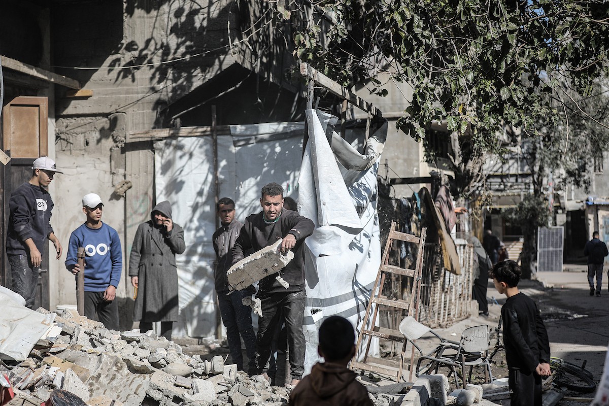 فلسطينيون يتفقدون منزلاً (تضرر سابقاً جراء غارة جوية إسرائيلية) انهار على سكانه، ما أسفر عن وفاة رجل ونجله الصغير في مخيم المغازي للاجئين وسط قطاع غزة، 5 يناير/كانون الثاني 2026. صورة: رمزي أبو عامر