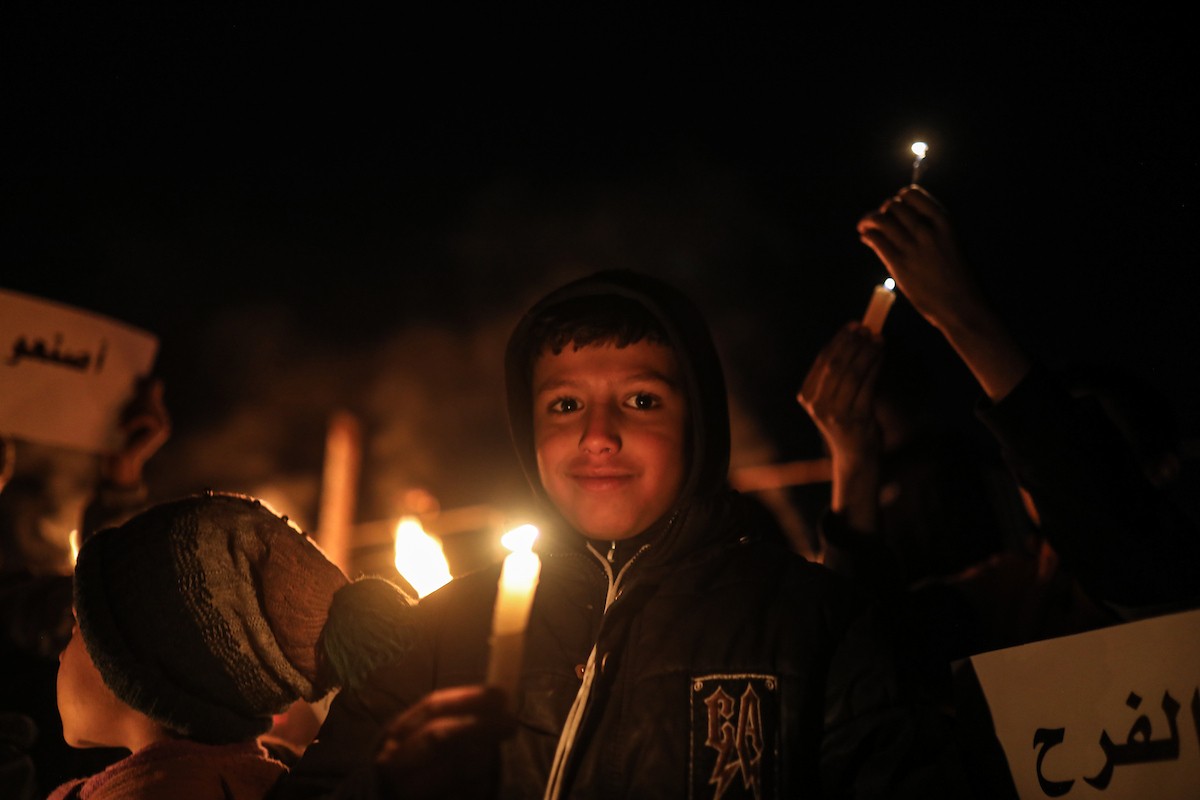 أطفال في وقفة احتجاجية في مخيم الشاطئ غرب مدينة غزة ليلة رأس السنة الميلادية 2026، 1 يناير/كانون الثاني 2026. تصوير: عمر أشتوي