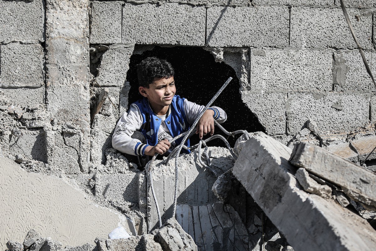 فلسطينيون يتفقدون منزلاً (تضرر سابقاً جراء غارة جوية إسرائيلية) انهار على سكانه، ما أسفر عن وفاة رجل ونجله الصغير في مخيم المغازي للاجئين وسط قطاع غزة، 5 يناير/كانون الثاني 2026. صورة: رمزي أبو عامر