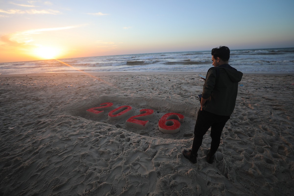 فلسطينيون يودعون عام 2025 بكتابة 2026 على رمال شاطئ غزة، 31 ديسمبركانون الأول 2025. صورة عمر أشتوي