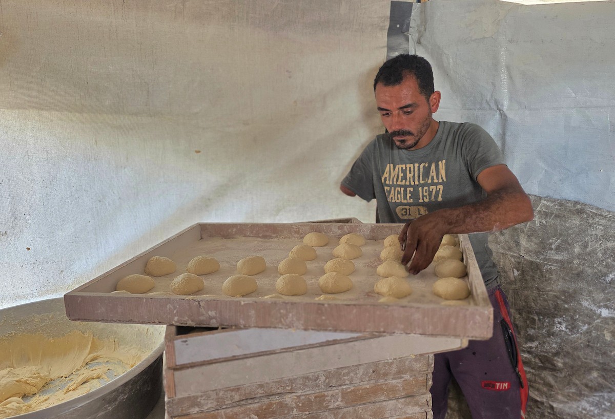 الفلسطيني محمد قحمان يعيد افتتاح مخبز تقليدي وسط أنقاض مدينة حمد غرب خان يونس، ويعمل جنباً إلى جنب مع أبنائه وصهره، وجميعهم من مبتوري الأطراف، 21 يناير/كانون الثاني 2026  . صورة: طارق محمد