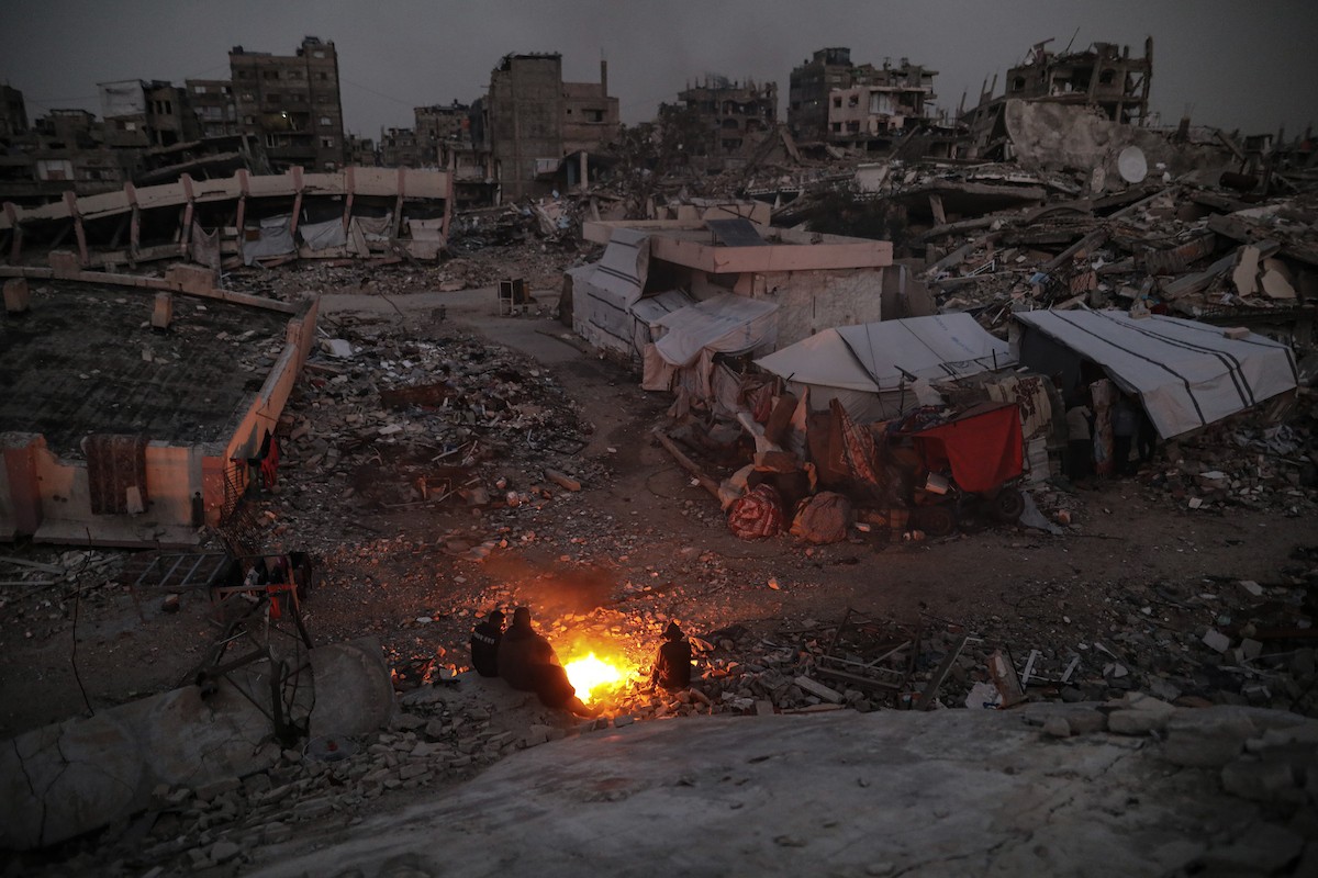 عائلات تعيش في خيام مؤقتة وسط الأنقاض تشعل نيرانًا للتدفئة في جباليا، شمال قطاع غزة، في 12 يناير/كانون الثاني 2026. ويكافح الفلسطينيون الذين دُمرت منازلهم في هجمات إسرائيلية من أجل البقاء في ظل ظروف شتوية قاسية وبرد قارس. صورة: عمر أشتوي