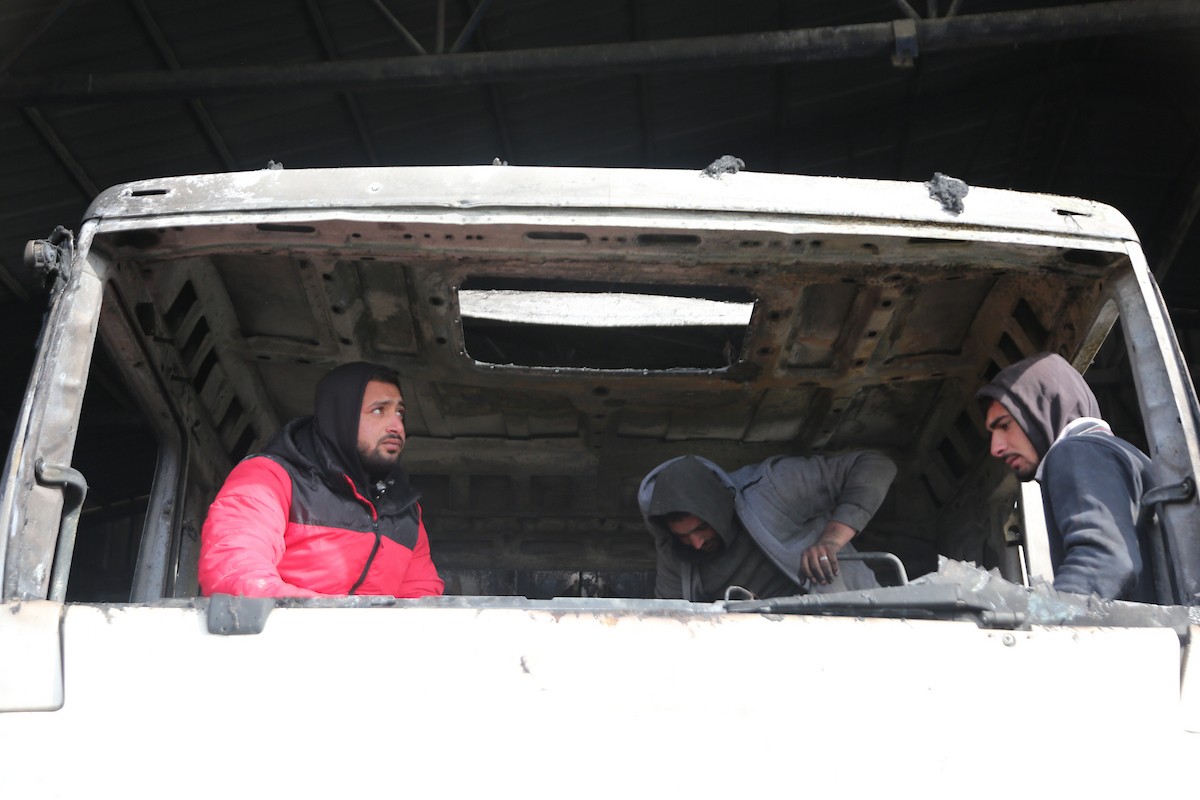 يتفقد الفلسطينيون الأضرار التي لحقت بمركباتهم وشاحناتهم وجرافاتهم بعد أن أضرم مستوطنون إسرائيليون النار فيها خلال هجوم شنوه على قرية عوريف، جنوب نابلس، في الضفة الغربية في 21 يناير/كانون الثاني 2026. صورة: محمد ناصر