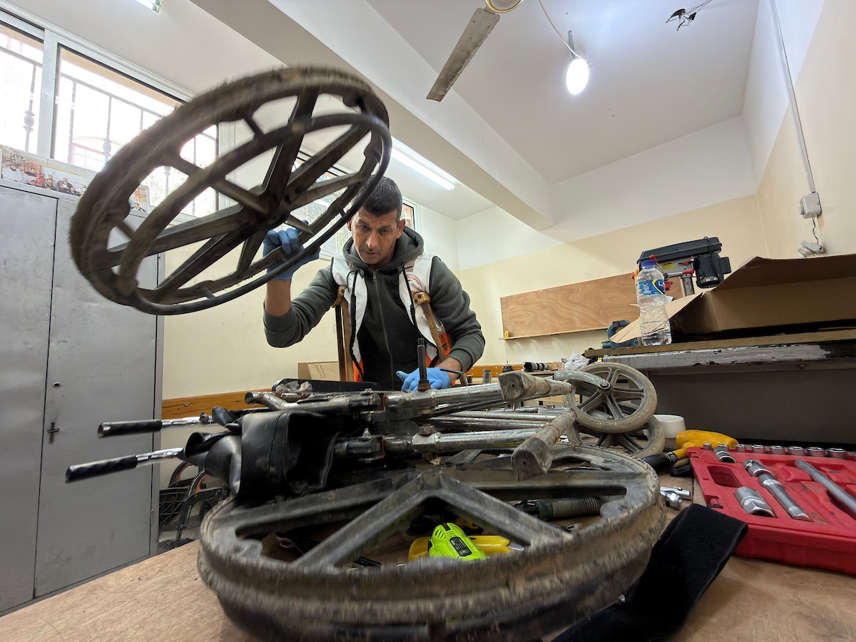 الفلسطيني رمزي الفجم يصلح كراسي متحركة لجرحى قطاع غزة متحديا إعاقته الشخصية ونقص المعدات الطبية ، خان يونس، جنوب قطاع غزة، 20 يناير/كانون الثاني 2026 تصوير: محمد سلامة / وكالة الأنباء الفلسطينية (APA Images)