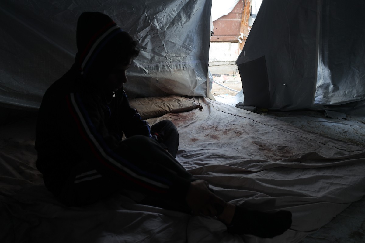 يكافح الشاب الفلسطيني أحمد أبو سعادة، البالغ من العمر عشرين عامًا، من أجل البقاء في خيمة مؤقتة بعد أن فقد زوجته، ولاء جحا، بعد ثلاثة أيام فقط من زفافهما، إثر غارة جوية إسرائيلية على غزة، 7 يناير/كانون الثاني 2025. صورة: عمر أشتوي