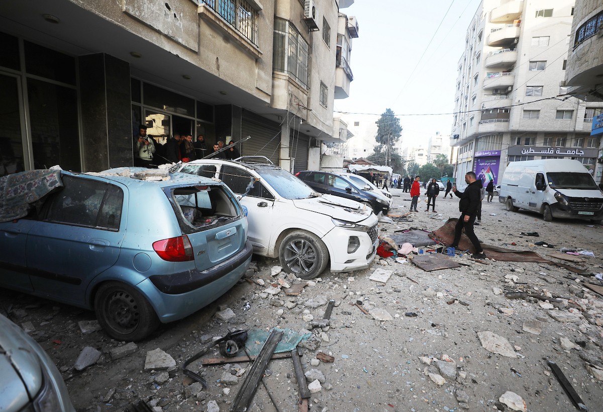 فلسطينيون يمرون أمام مبنى سكني تضرر جراء غارة عسكرية إسرائيلية أسفرت عن سقوط عدد من الضحايا في مدينة غزة، السبت 31 يناير/كانون الثاني 2026. صورة: عمر أشتوي