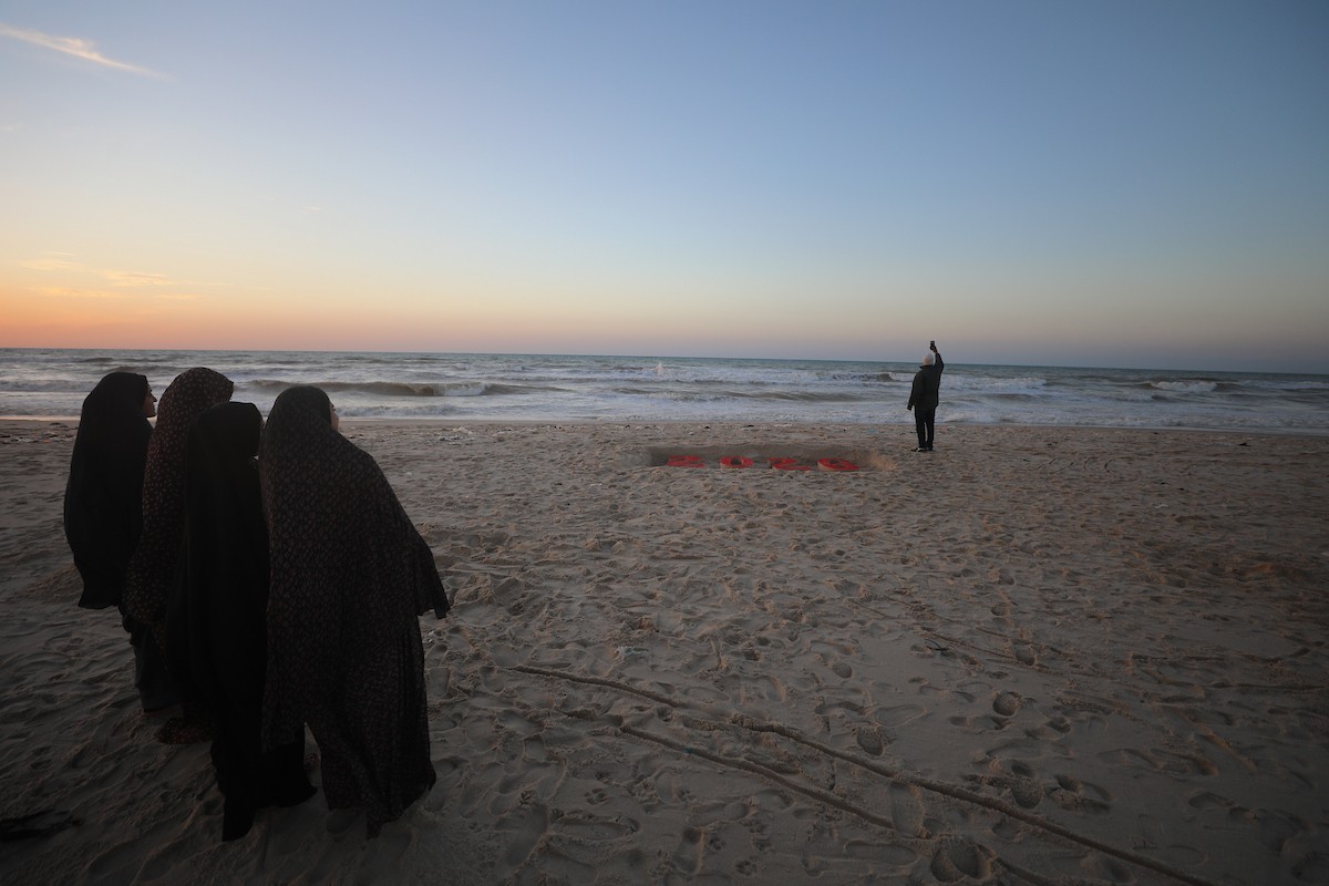 فلسطينيون يودعون عام 2025 بكتابة 2026 على رمال شاطئ غزة، 31 ديسمبركانون الأول 2025. صورة عمر أشتوي