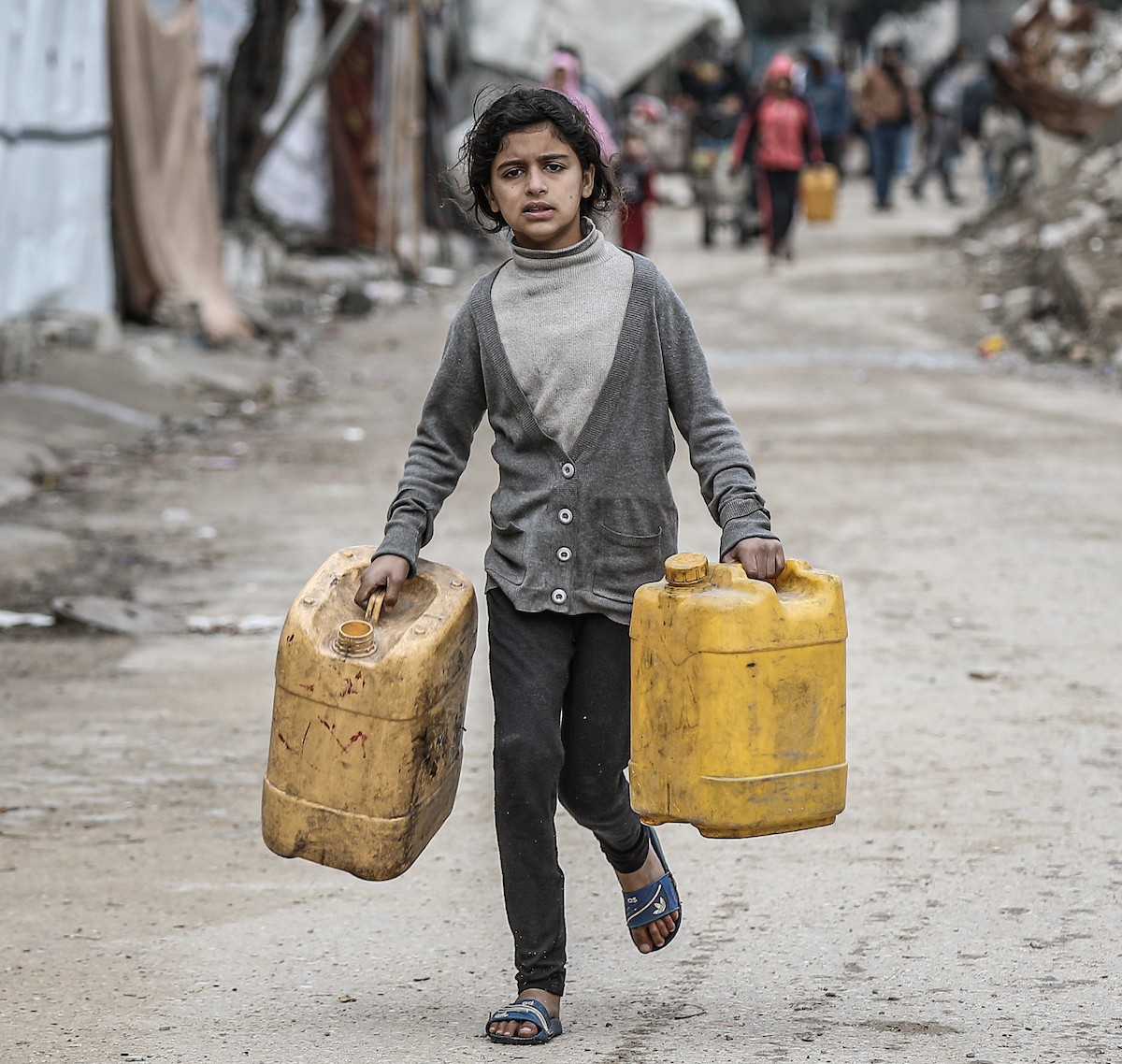 يملأ الفلسطينيون خزاناتهم بالمياه التي توزعها صهاريج المياه، وينقلونها إلى خيامهم في مخيم النصيرات وسط قطاع غزة، حيث تفاقمت أزمة المياه نتيجة الأضرار الجسيمة التي لحقت بالبنية التحتية جراء الهجمات الإسرائيلية، 29 يناير/كانون الثاني 2026. صورة: رمزي أبو عامر