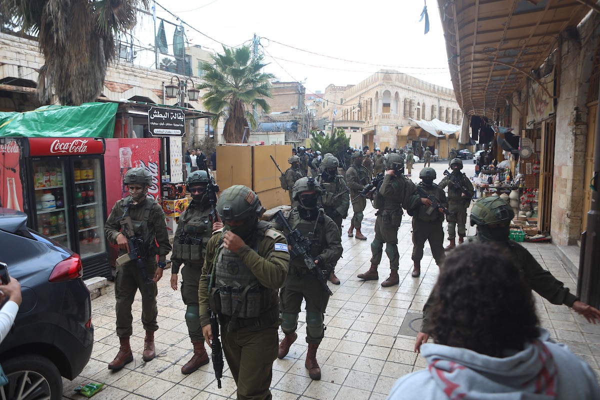 جنود إسرائيليون يقفون في دورية حراسة خلال جولة أسبوعية للمستوطنين في مدينة الخليل، جنوب الضفة الغربية ، 10 يناير/كانون الثاني 2026. تصوير: مأمون وزواز