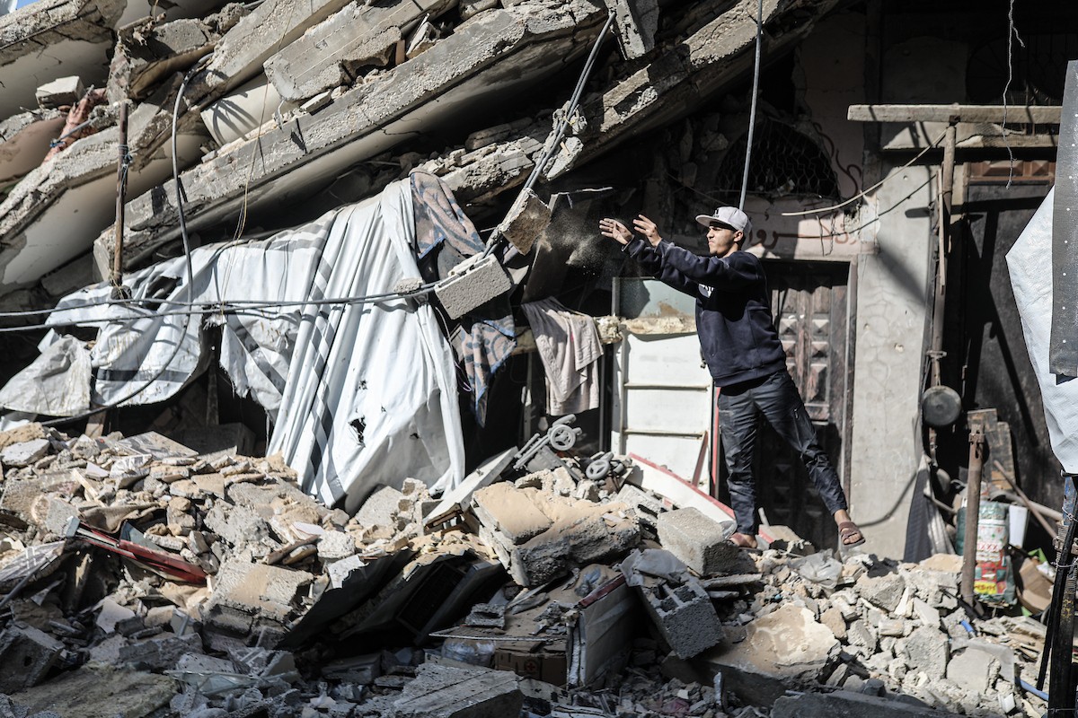 فلسطينيون يتفقدون منزلاً (تضرر سابقاً جراء غارة جوية إسرائيلية) انهار على سكانه، ما أسفر عن وفاة رجل ونجله الصغير في مخيم المغازي للاجئين وسط قطاع غزة، 5 يناير/كانون الثاني 2026. صورة: رمزي أبو عامر