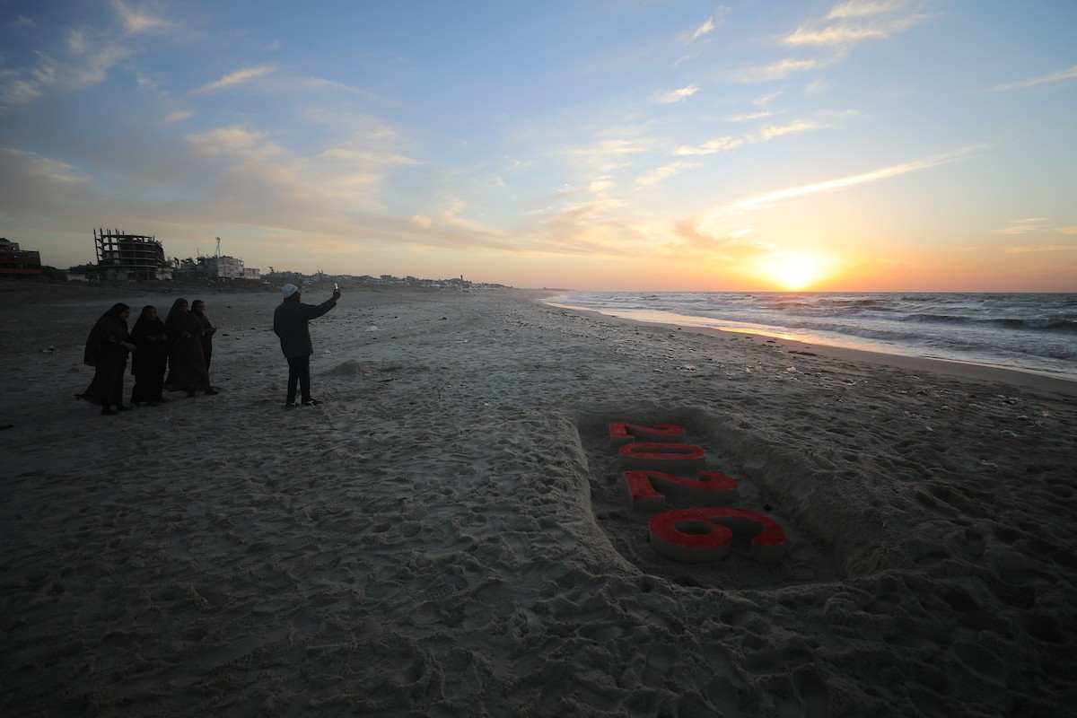 فلسطينيون يودعون عام 2025 بكتابة 2026 على رمال شاطئ غزة، 31 ديسمبركانون الأول 2025. صورة عمر أشتوي