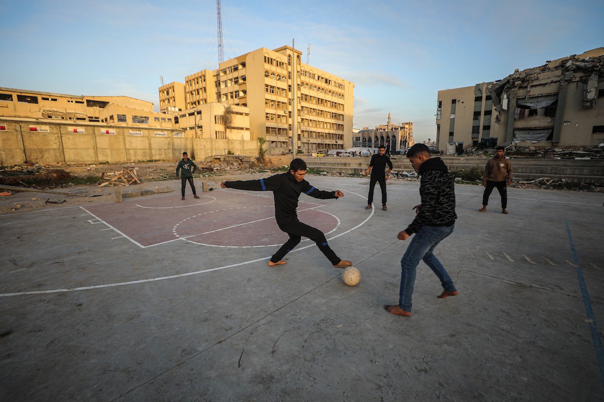   شبان فلسطينيون نازحون يلعبون كرة القدم في ملعب مدمر بمدينة غزة، في 10 يناير/كانون الثاني 2026. صورة: عمر أشتوي