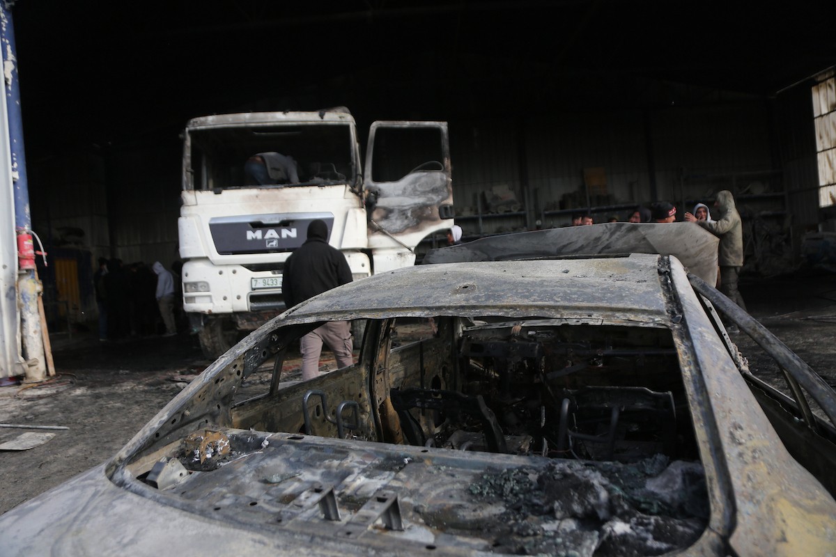 يتفقد الفلسطينيون الأضرار التي لحقت بمركباتهم وشاحناتهم وجرافاتهم بعد أن أضرم مستوطنون إسرائيليون النار فيها خلال هجوم شنوه على قرية عوريف، جنوب نابلس، في الضفة الغربية في 21 يناير/كانون الثاني 2026. صورة: محمد ناصر
