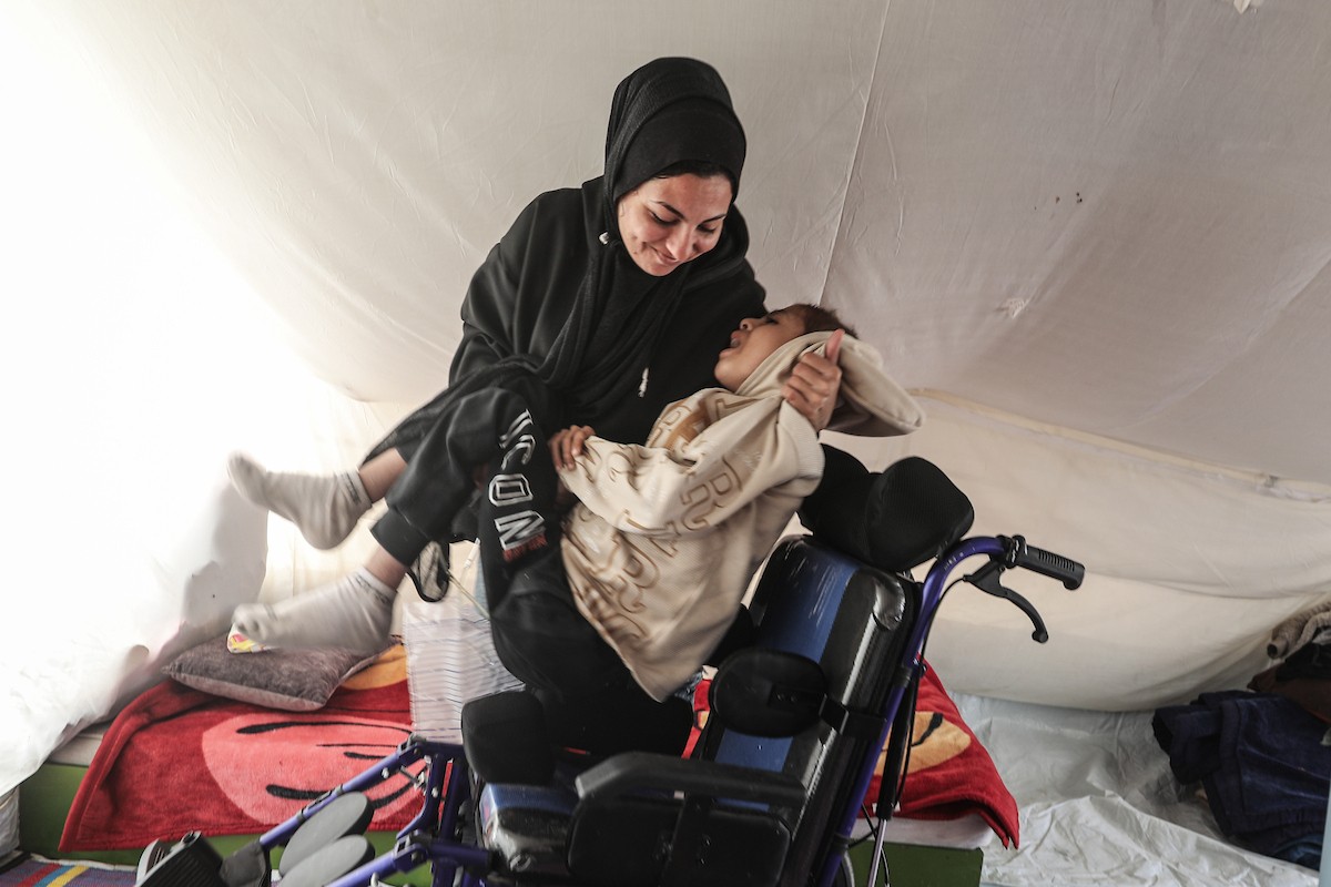 الطفل سيف رامي حجازي (13 عاما) أُصيب بشلل كامل وفشل كلوي إثر قصف إسرائيلي لخيمة عائلته، وتتولى والدته رعايته في ظروف إنسانية بالغة الصعوبة بمخيم المغازي، وسط قطاع غزة، 30 يناير/كانون الثاني 2026. صورة: معز صالحي