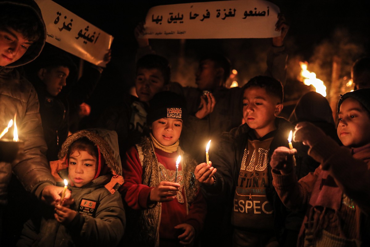 أطفال في وقفة احتجاجية في مخيم الشاطئ غرب مدينة غزة ليلة رأس السنة الميلادية 2026، 1 يناير/كانون الثاني 2026. تصوير: عمر أشتوي