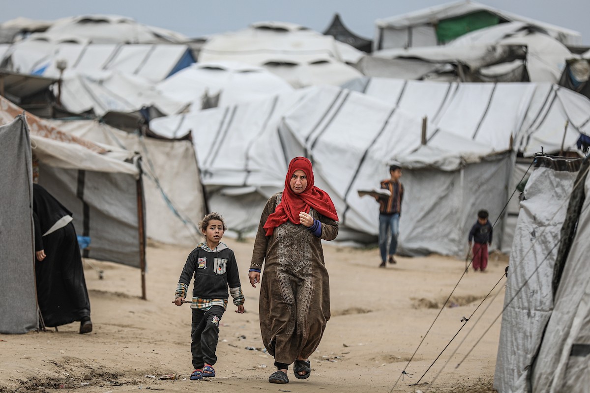 يتفقد فلسطينيون نازحون خيامهم بعد أن تضررت بشدة جراء عاصفة هوائية قوية ضربت مخيمًا للنازحين وسط قطاع غزة. 22 يناير/كانون الثاني 2026. تصوير: رمزي أبو عامر