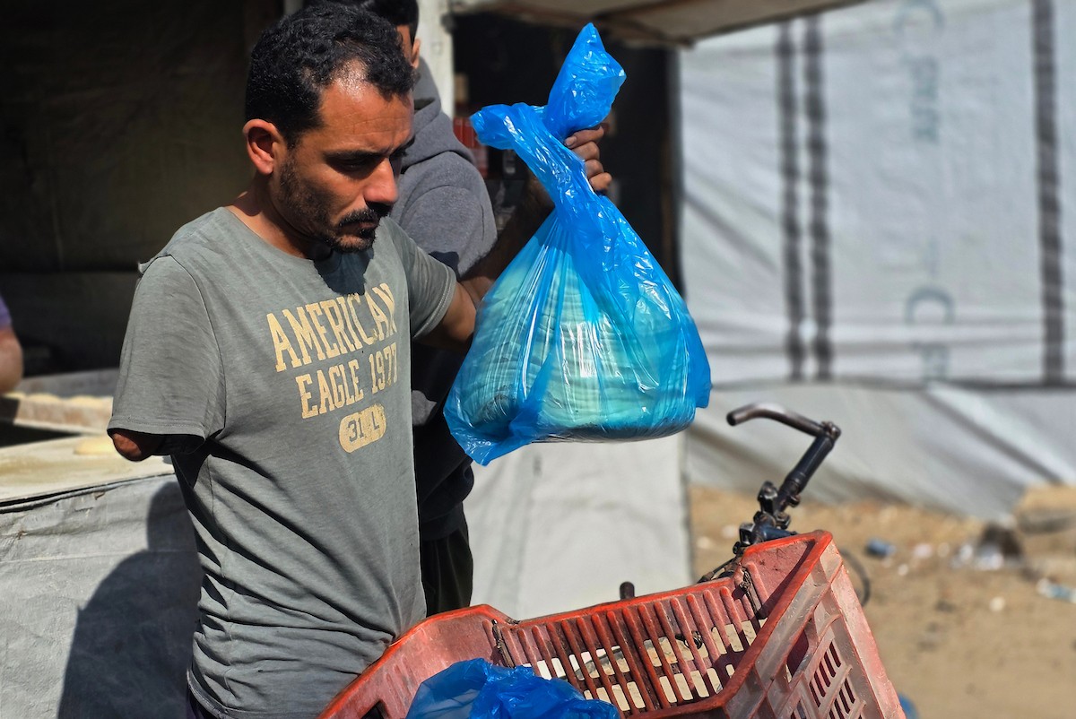 الفلسطيني محمد قحمان يعيد افتتاح مخبز تقليدي وسط أنقاض مدينة حمد غرب خان يونس، ويعمل جنباً إلى جنب مع أبنائه وصهره، وجميعهم من مبتوري الأطراف، 21 يناير/كانون الثاني 2026  . صورة: طارق محمد