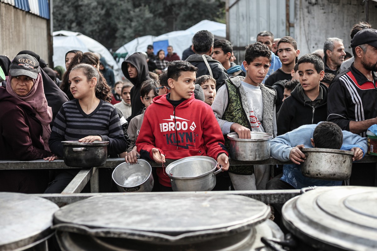 تلقى فلسطينيون، بينهم أطفال، وجبات ساخنة وزعتها إحدى الجمعيات الخيرية في مخيم النصيرات للاجئين، وسط نقص حاد في الغذاء ناجم عن الهجمات الإسرائيلية المستمرة وتدهور الأوضاع الإنسانية. النصيرات، وسط قطاع غزة. 26 يناير/كانون الثاني 2026. تصوير: معز صالحي