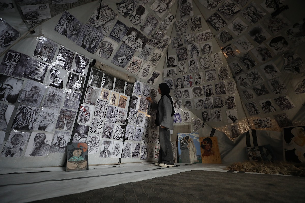 الفلسطينية مرَح خالد الزعانين (18 عاما) تحول خيمة نزوحها في مدينة غزة إلى معرض فني، 28 يناير/كانون الثاني 2026. تصوير: عمر أشتوي