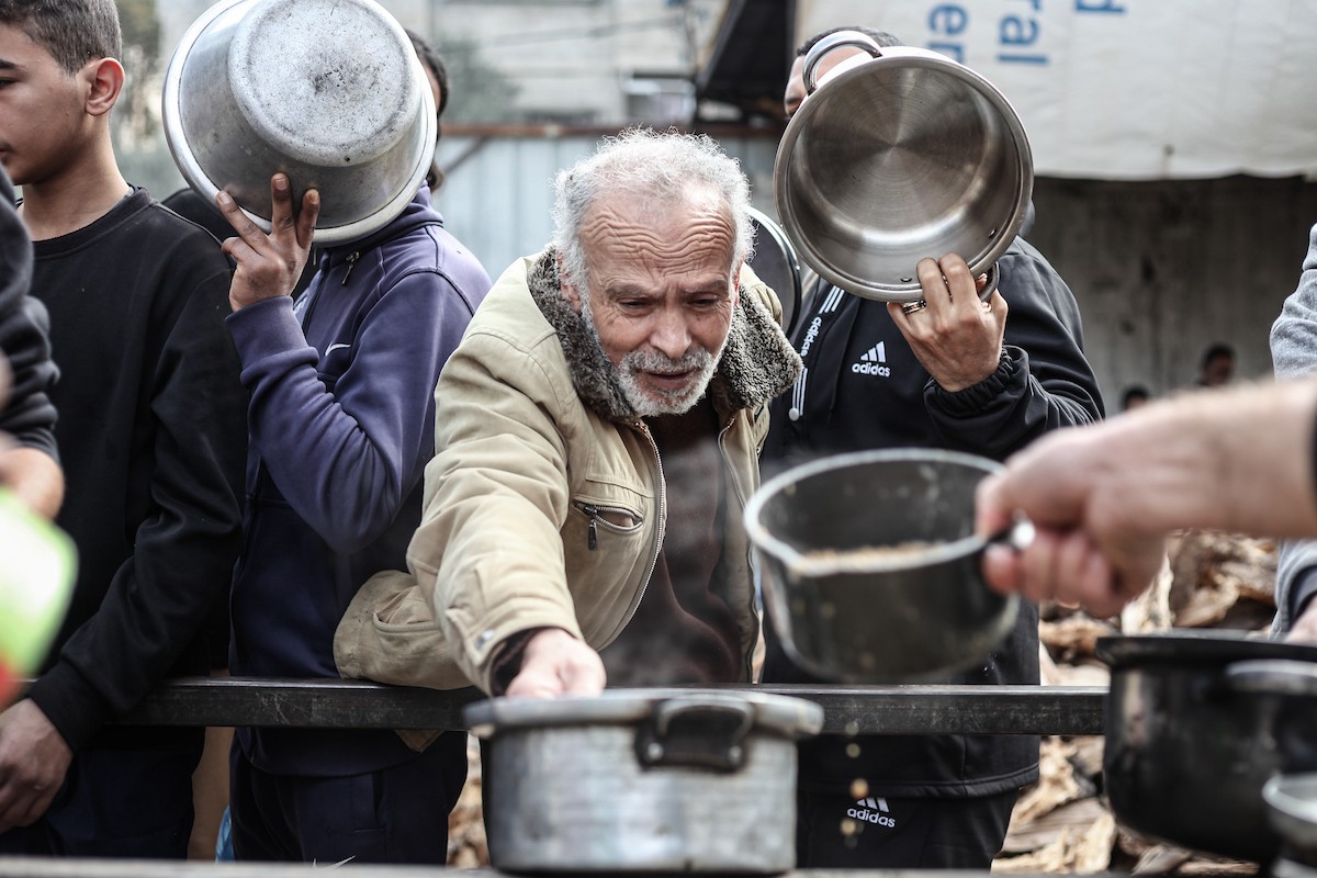 تلقى فلسطينيون، بينهم أطفال، وجبات ساخنة وزعتها إحدى الجمعيات الخيرية في مخيم النصيرات للاجئين، وسط نقص حاد في الغذاء ناجم عن الهجمات الإسرائيلية المستمرة وتدهور الأوضاع الإنسانية. النصيرات، وسط قطاع غزة. 26 يناير/كانون الثاني 2026. تصوير: معز صالحي